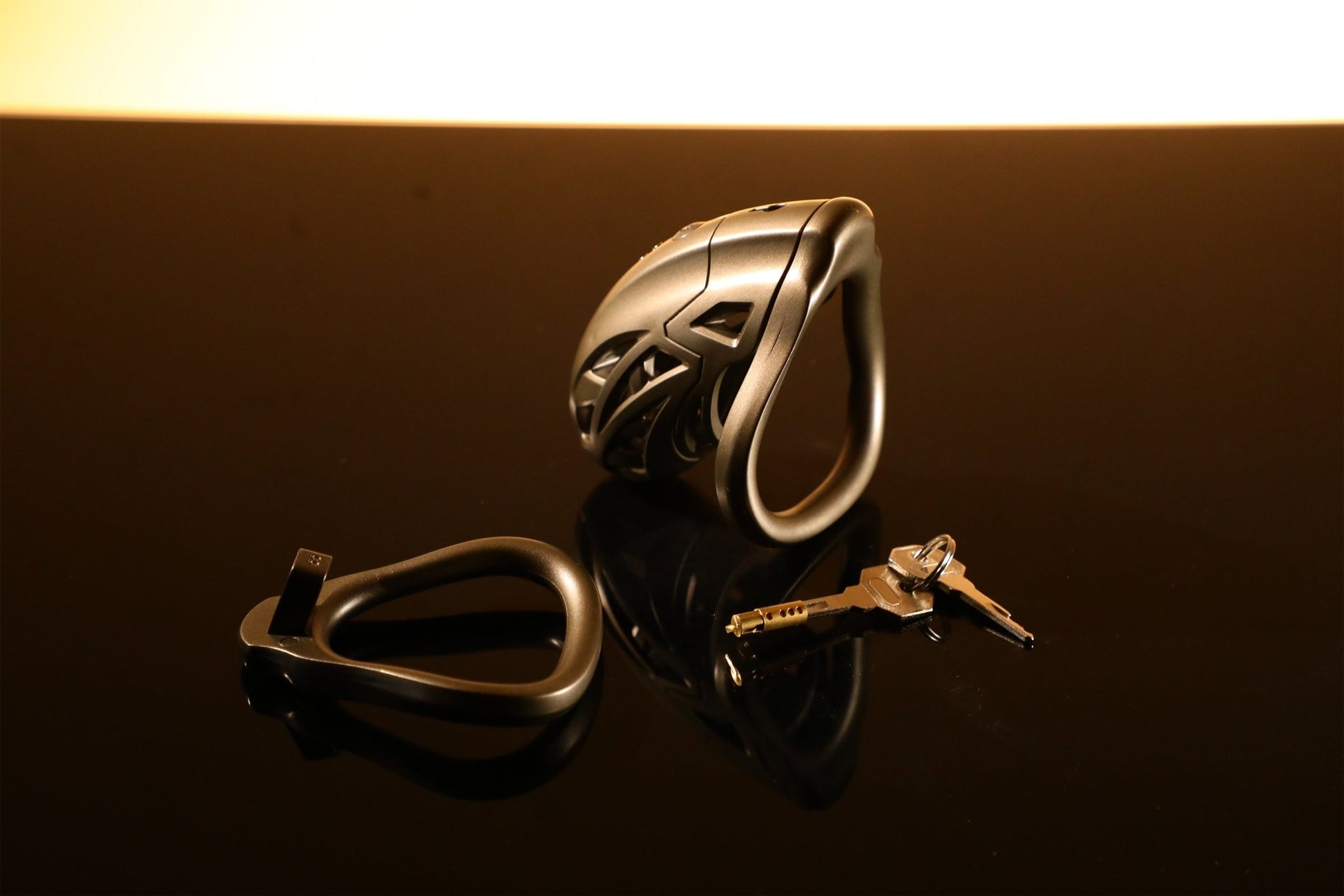 The bronze metal male chastity cage set is displayed on the table