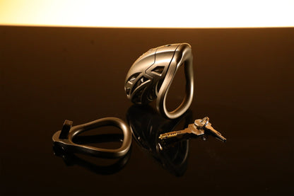 The bronze metal male chastity cage set is displayed on the table